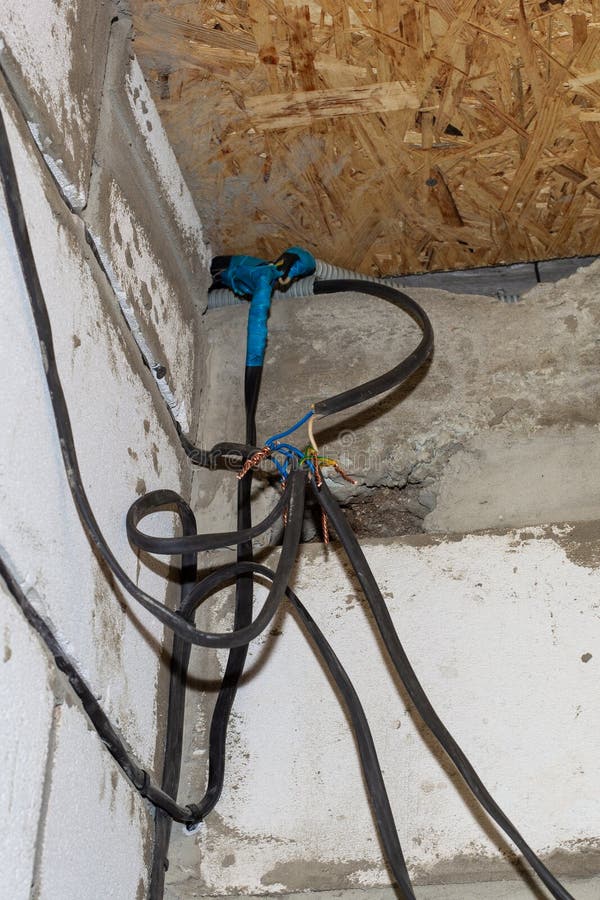 Connection of Wires Against the Background of a Wall in a House Under