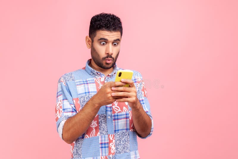 Connexion mobile. portrait d'un homme étonné choqué en chemise bleue lire un billet sur le réseau social en utilisant la conversat photo libre de droits