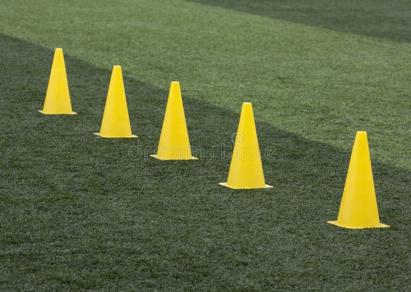 Yellow training cones on a training pitch. Yellow training cones on a training pitch