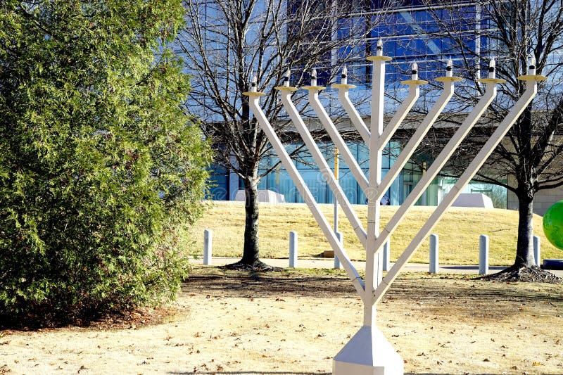 The seven lamps of the menorah relate to the branches of human knowledge, with the six lamps looking inwards and symbolically guided by, the light of God which is represented by the central lamp. The menorah also symbolizes the Earth's creation in seven days, with the center light representing the Sabbath. This is outside the Clinton Presidential library in Little Rock, Arkansas. The seven lamps of the menorah relate to the branches of human knowledge, with the six lamps looking inwards and symbolically guided by, the light of God which is represented by the central lamp. The menorah also symbolizes the Earth's creation in seven days, with the center light representing the Sabbath. This is outside the Clinton Presidential library in Little Rock, Arkansas.