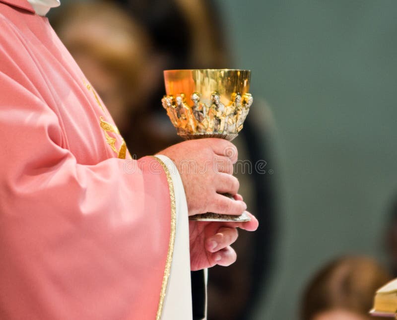 From the altar of the church the priest`s hand consecrates the blood wine of Christ and shows it to all the faithful. From the altar of the church the priest`s hand consecrates the blood wine of Christ and shows it to all the faithful