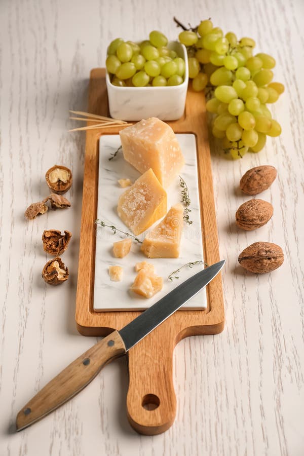 Conseil avec du fromage et les raisins savoureux sur la table en bois blanche photos libres de droits Conseil avec du fromage et les raisins savoureux sur la table en bois blanche photos libres de droits