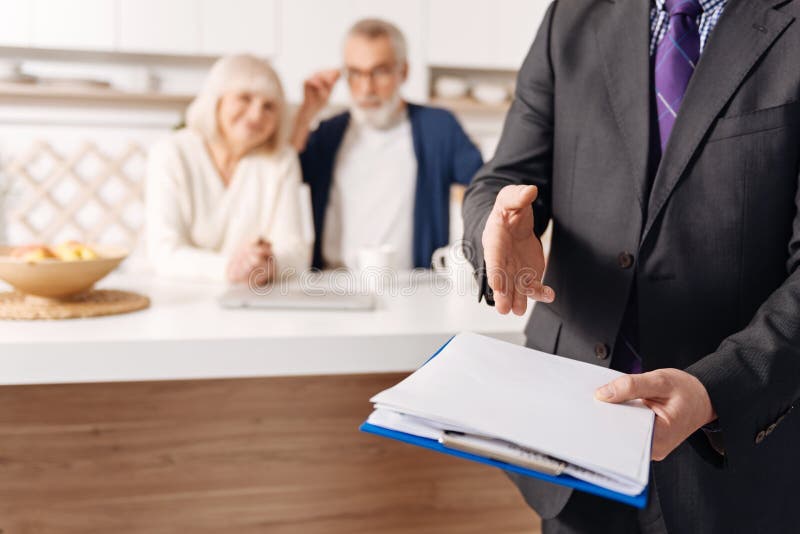 Conseiller crédible de sécurité sociale démontrant le document pour les couples pluss âgé images stock Conseiller crédible de sécurité sociale démontrant le document pour les couples pluss âgé images stock