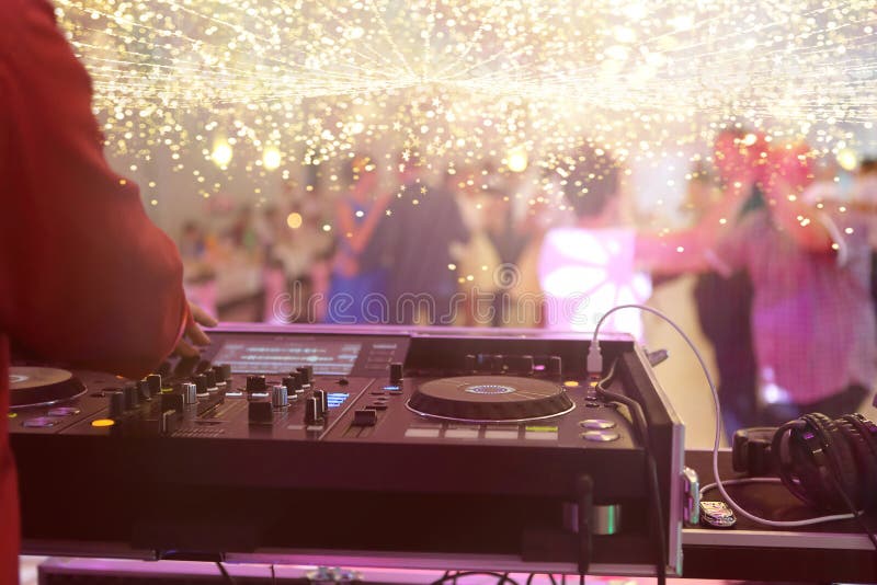 Consola de mixare este cântată de DJ și cupluri care dansează pe ringul de dans în fundal royalty free stock photo
