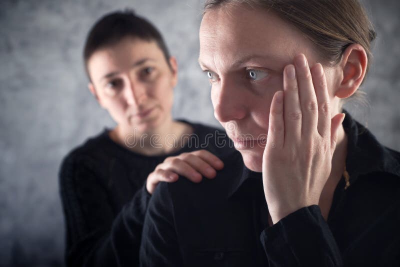 Comforting friend. Woman consoling her sad friend with hand on shoulder. Comforting friend. Woman consoling her sad friend with hand on shoulder.