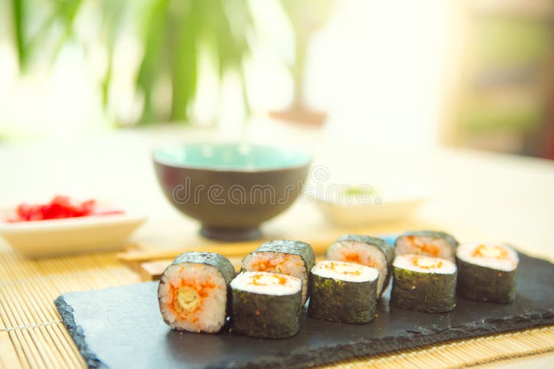 Consommation des sushi avec des baguettes Nourriture japonaise de petit pain de sushi dans le restaurant Ensemble de petit pain d photos libres de droits Consommation des sushi avec des baguettes Nourriture japonaise de petit pain de sushi dans le restaurant Ensemble de petit pain d photos libres de droits