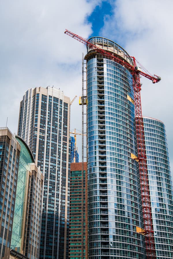 Construcción de edificios modernos de oficinas y residencias de vidrio y acero con grúas rojas y amarillas fotos de archivo libres de regalías Construcción de edificios modernos de oficinas y residencias de vidrio y acero con grúas rojas y amarillas fotos de archivo libres de regalías