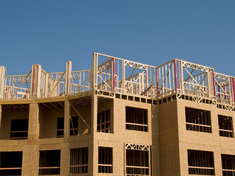 Urban construction site under a blue sky with white clouds. Woodframe on a concrete substructure. Urban construction site under a blue sky with white clouds. Woodframe on a concrete substructure.