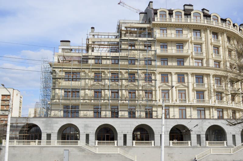 Construcción de un edificio de varios pisos en la ciudad. La construcción de un edificio de varios pisos en la parte de la ciudad de la fachada del edificio está cubierta de bosques de construcción en los que se realizarán trabajos de cara