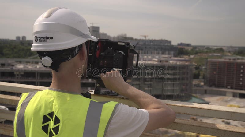 Constructeur dans casque appuie sur les touches de l'appareil photo numérique sur le toit banque de vidéos