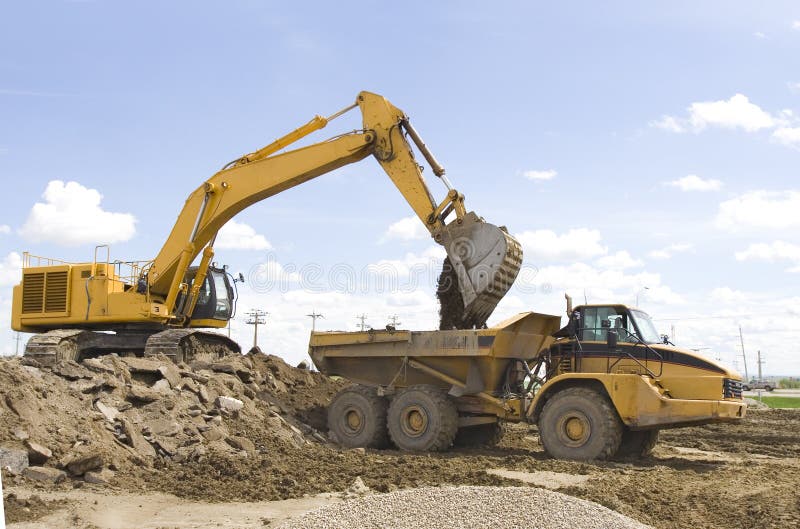 A hoe filling up a dump truck. Claw machine stock images, royalty-free photos and pictures