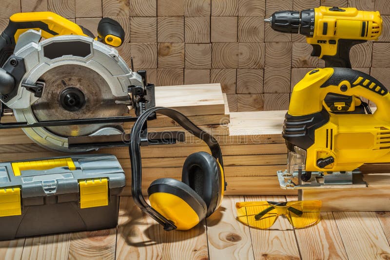 Construction carpentry electric hand tools on wooden background
