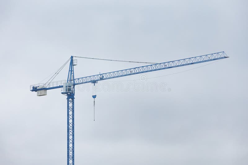 Construction crane against sky. Construction crane against cloudy sky, industrial infrastructure and urban development concept with copy space. Load structural stock images, royalty-free photos and pictures