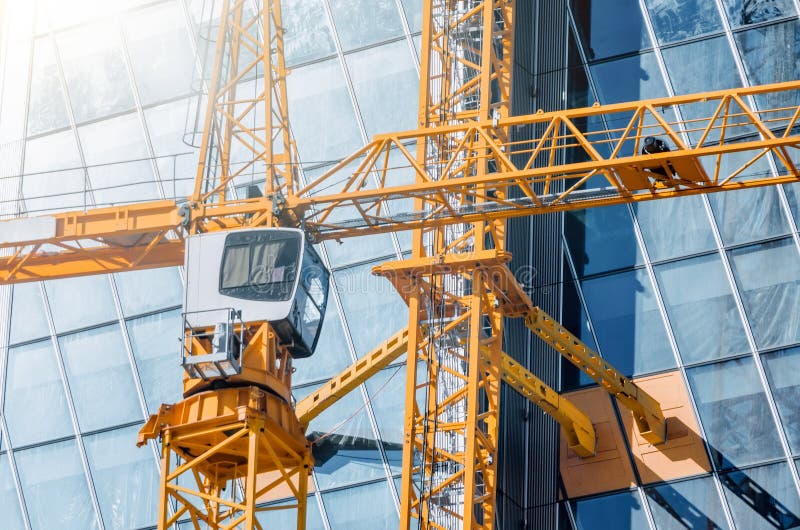 Construction Crane and a Crane Driver`s Cab Closeup on the Window of a