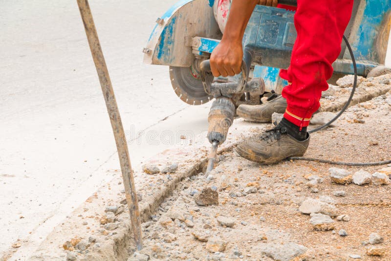 Construction Drilling Repair Worker on Road Surface with Heavy Duty ...