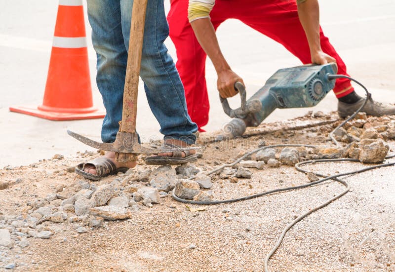 Construction Drilling Repair Worker on Road Surface with Heavy Duty