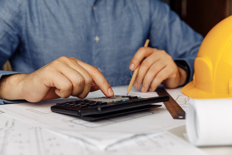 Construction Engineer Using Calculator for Analysis in the Office
