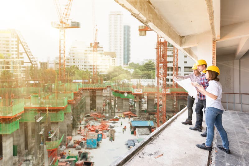 3 construction engineers working together discuss with blueprint stock photos