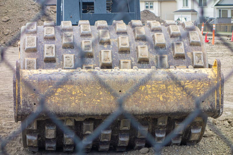 Construction Equipment Behind a Wire Mesh Fence on Site Stock Photo