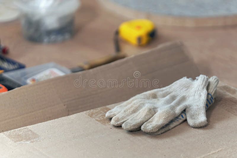 Construction Gloves are on the Cardboard Box, Closeup Stock Photo
