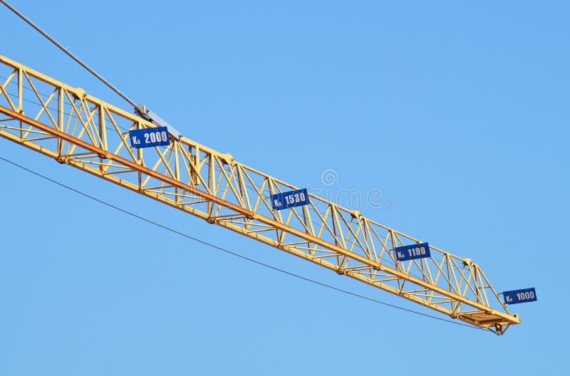 Construction industry tower crane against clear blue sky