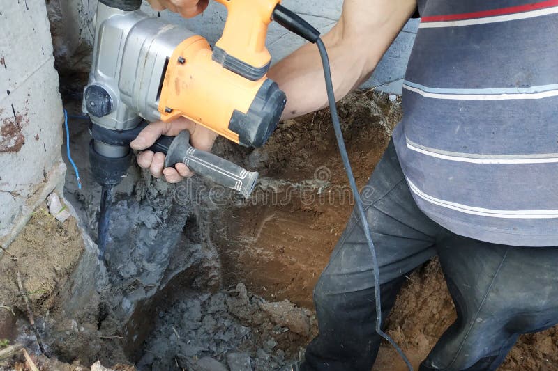 Construction Industry Worker Using Pneumatic Hammer Drill To Cut the