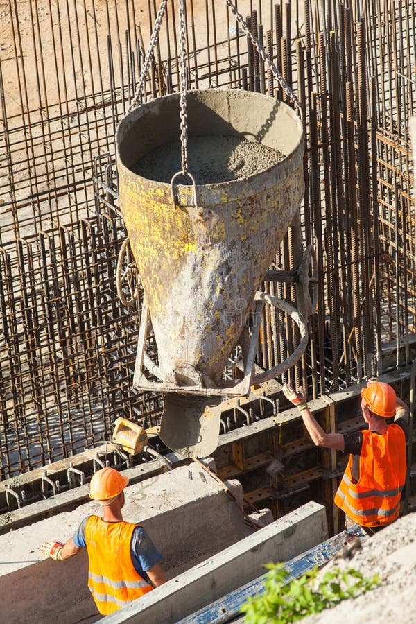 Construction of a large commercial building. Two construction workers ready fill formwork by cement and concrete stock images Construction of a large commercial building. Two construction workers ready fill formwork by cement and concrete stock images