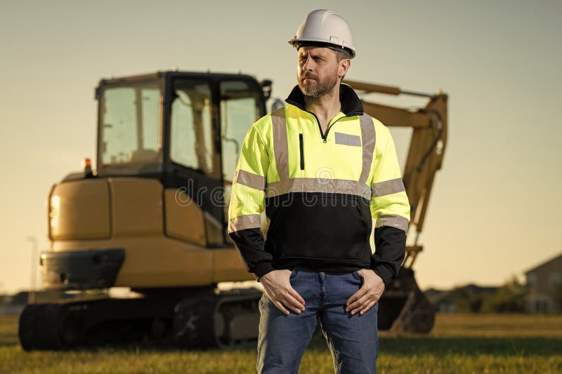 Construction man industry with excavator at industrial site. Worker in helmet build with bulldozer. Engineer work with builder stock photography