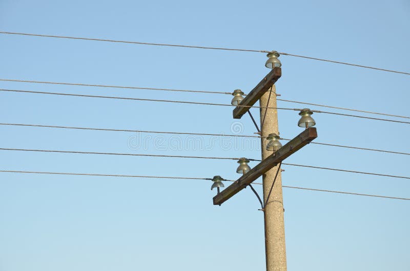 Construction for mounting a overhead power lines on top of column against blue sky stock photo