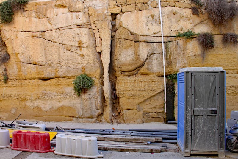 Construction and repair work takes place on a road and deep cutting in Sliema in Malta royalty free stock image