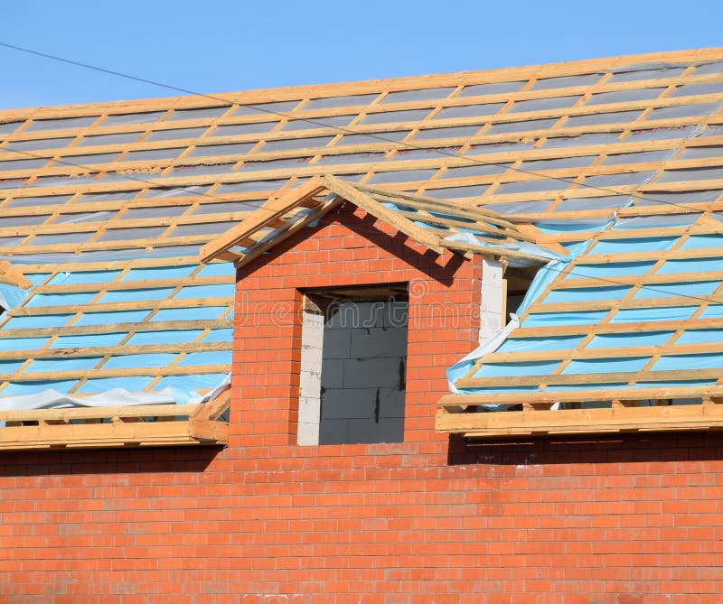 Construction of the roof of a new house. Wooden bars and vapor barrier under the corrugated metal profile