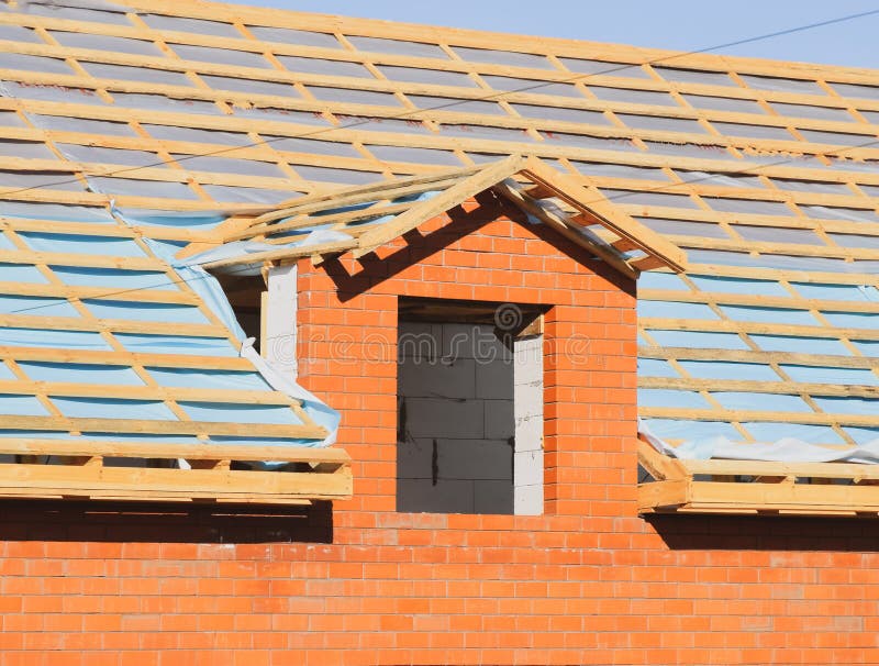 Construction of the roof of a new house. Wooden bars and vapor barrier under the corrugated metal profile