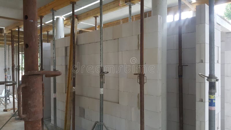 Interior view of a building under construction, showcasing walls made of concrete blocks and temporary support poles holding up the ceiling beams. Load structural stock images, royalty-free photos and pictures