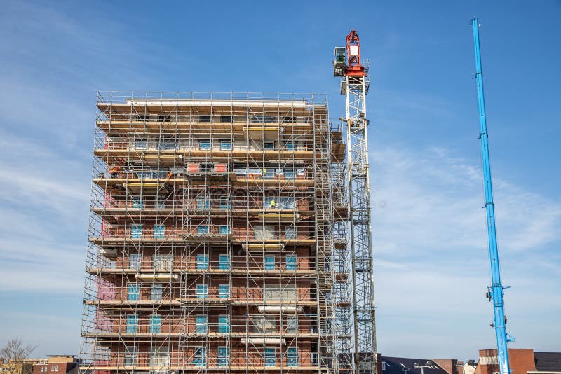 Construction site new apartment building with scaffolding and mason workers royalty free stock photography