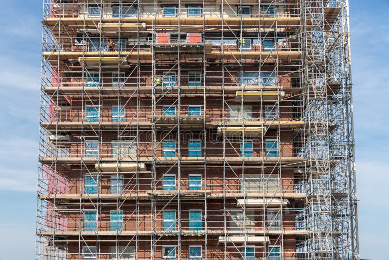 Construction site new apartment building with scaffolding and mason workers royalty free stock photos
