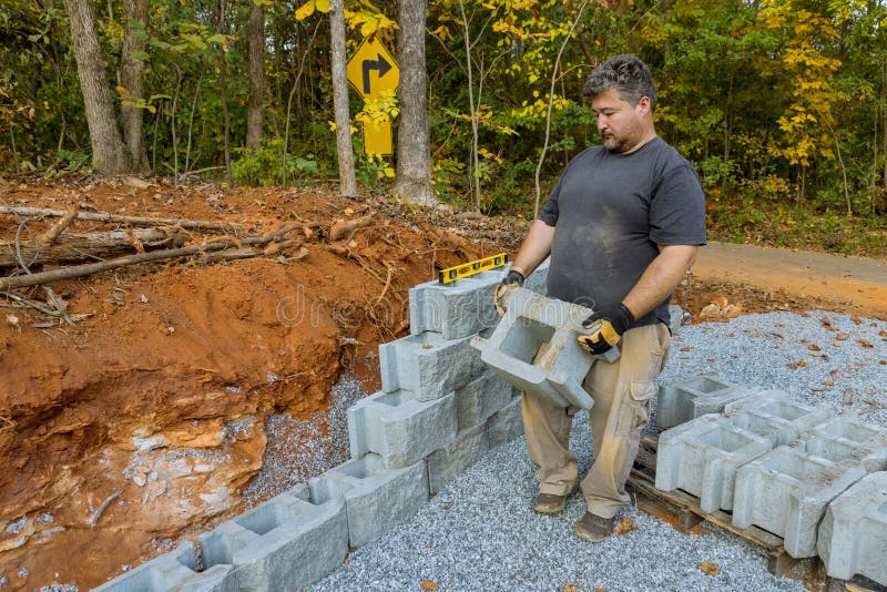 On the Construction Site of a New Large Block Retaining Wall, a Contractor Was Seen Installing