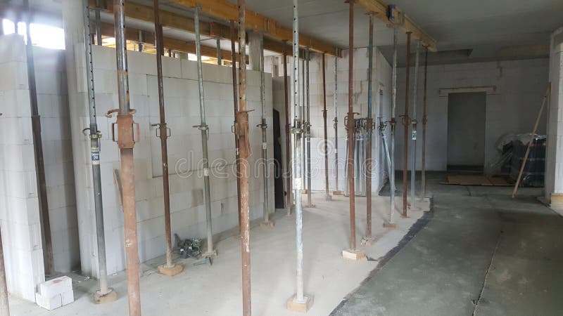 Interior view of a building under construction, showcasing a dense arrangement of adjustable steel props supporting the overhead structure. Load structural stock images, royalty-free photos and pictures