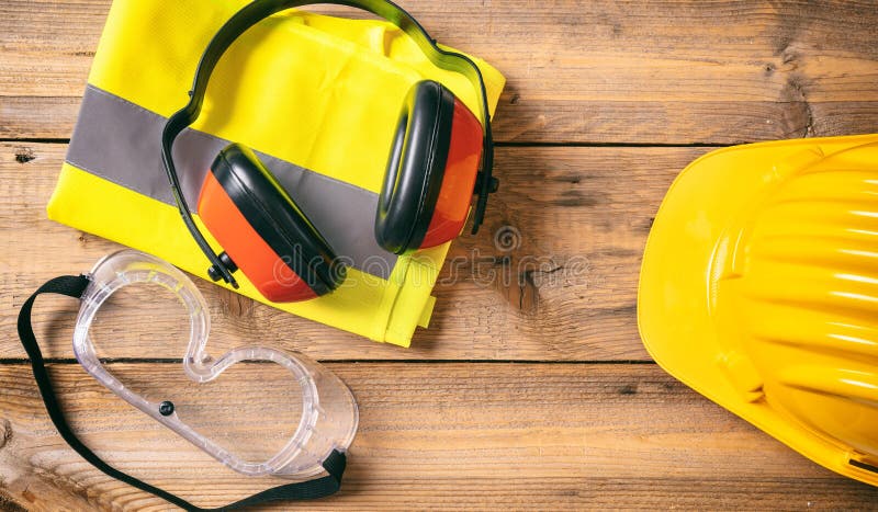 Construction safety. Protective hard hat, headphones and glasses on wooden background, copy space, top view royalty free stock images Construction safety. Protective hard hat, headphones and glasses on wooden background, copy space, top view royalty free stock images
