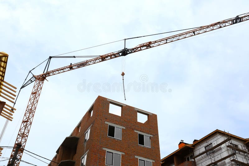 Construction Site with Tower Crane Near Unfinished Buildings, Low Angle
