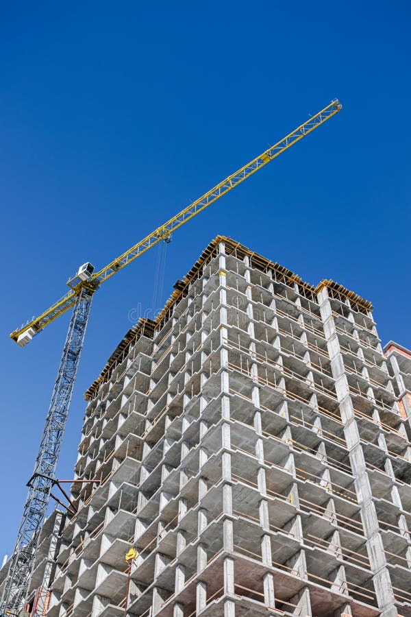 Unfinished Concrete Building Under Construction on Blue Sky Stock Photo