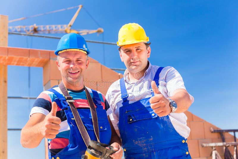 Construction site workers building walls on house royalty free stock photography