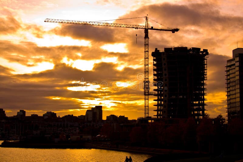 High rise architecture in Vancouver, Canada. Glass towers and modern skyscraper residential. A residential tower towards the end of the construction with a crane on the side. Any modern city in the evening during construction. Vancouver skyscraper stock images, royalty-free photos and pictures