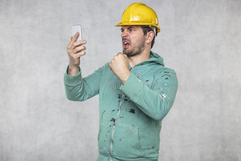 Construction supervisor is shouting to a cell phone, copy space next to him royalty free stock photos