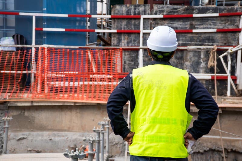 Construction Supervisor Wearing green safety shirt Standing back Looking at the front Check the work done In the area that is royalty free stock photo