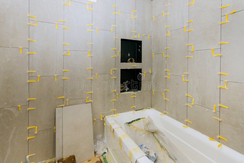 Construction work installing ceramic tile on reconstruction of bathroom royalty free stock photography