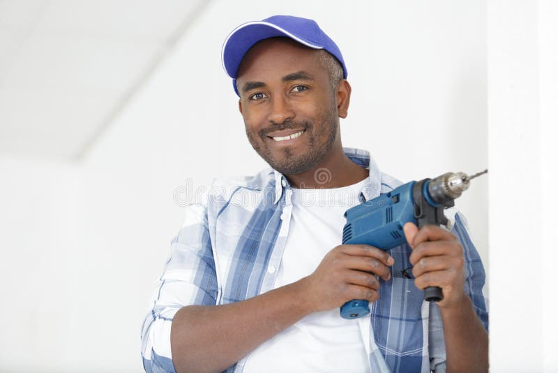 Construction Worker Drilling Hole in Wall in New House Stock Image