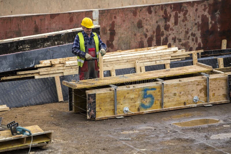 Construction Worker with Hammer Fabricating Formwork, Editorial Photo