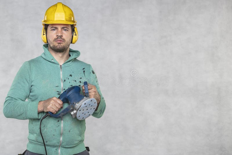 The construction worker holds a new grinder in his hand, copy space royalty free stock photo