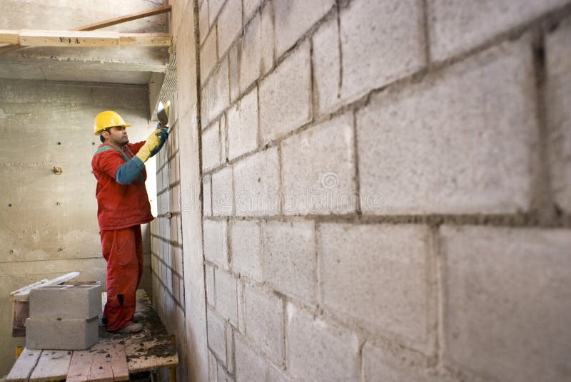 Construction Worker Lays Cinder Block - Horizontal