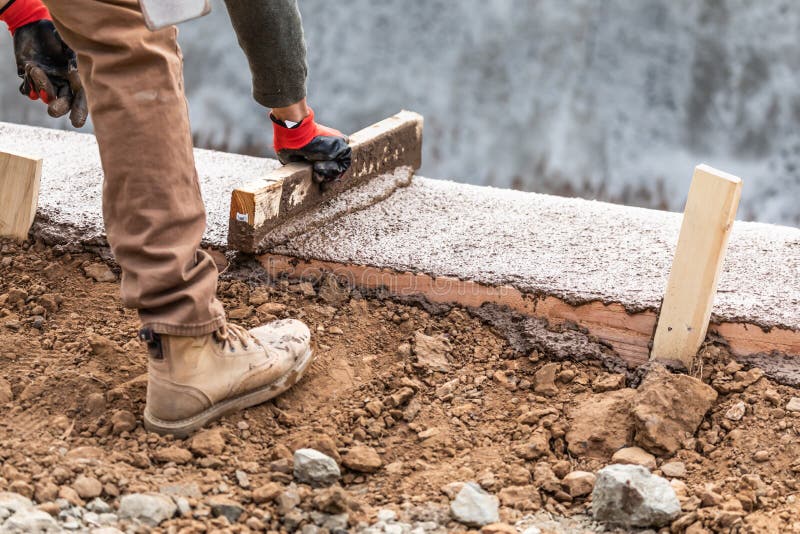 Construction Worker Leveling Wet Cement Into Wood Framing Stock Image